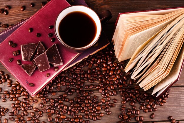 Filiżanka kawy stojaki na książce z czekoladą