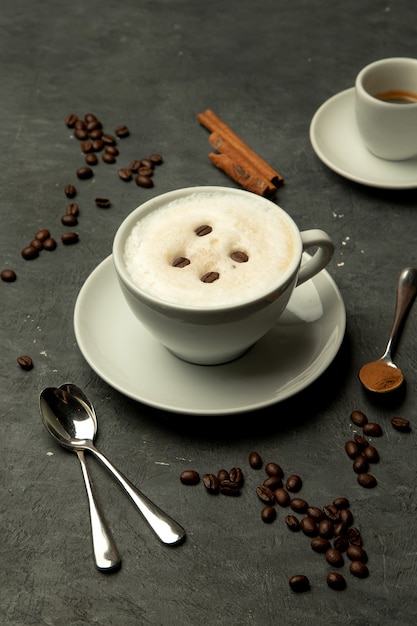 Filiżanka spienionego latte zwieńczona ziarnami kawy