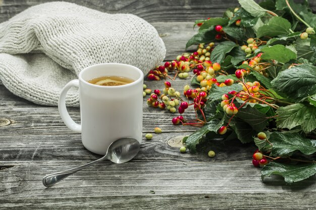 filiżankę herbaty na pięknym drewnianym tle sweter zima, jagody, jesień