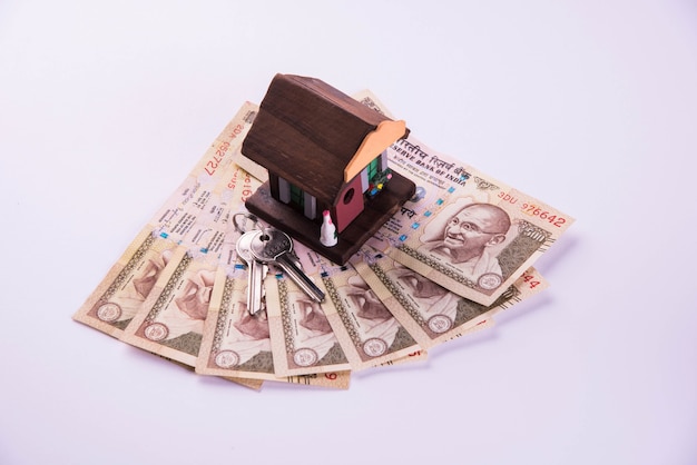 Finanse i kredyt mieszkaniowy lub zakup w indiach - koncepcja przedstawiająca model domu 3d, banknoty w indyjskiej walucie i kalkulator itp.