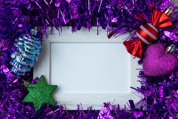 Fioletowa dekoracja z ramką na zdjęcia i zabawkami jako koncepcja nowego roku na rozmytym tle
