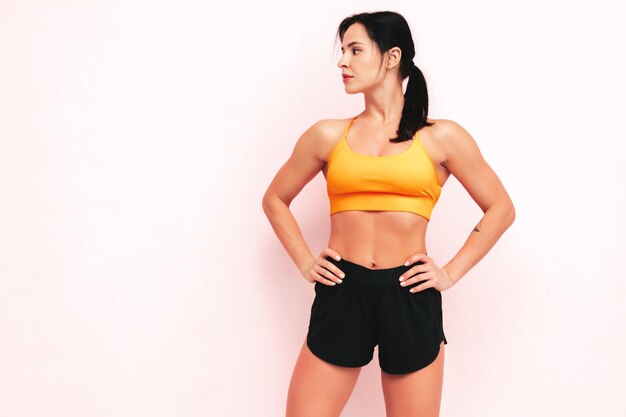 Fitness pewna siebie kobieta w sportowej odzieży Seksowna młoda piękna modelka z idealnym ciałem Kobieta pozuje w studio Rozciąganie się przed treningiem