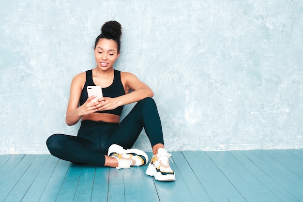 Fitness uśmiechnięta kobieta w sportowej odzieży z fryzurą afro loki