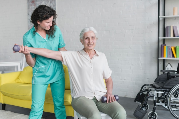 Bezpłatne zdjęcie fizjoterapeuta pracuje z starszym pacjentem w nowożytnej klinice
