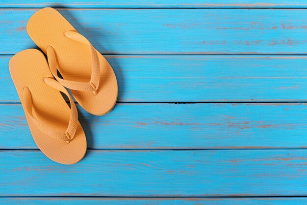 Flip flops na starym wyblakłym niebieskim plaży drewna