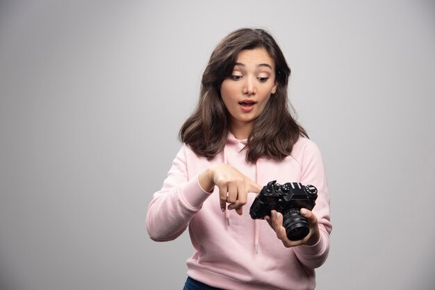 Fotograf kobieta szczęśliwie patrząc na zdjęcia w aparacie.