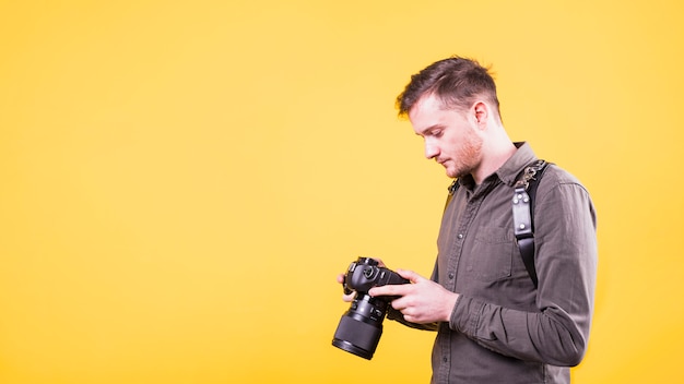 Bezpłatne zdjęcie fotograf patrząc na ekran aparatu