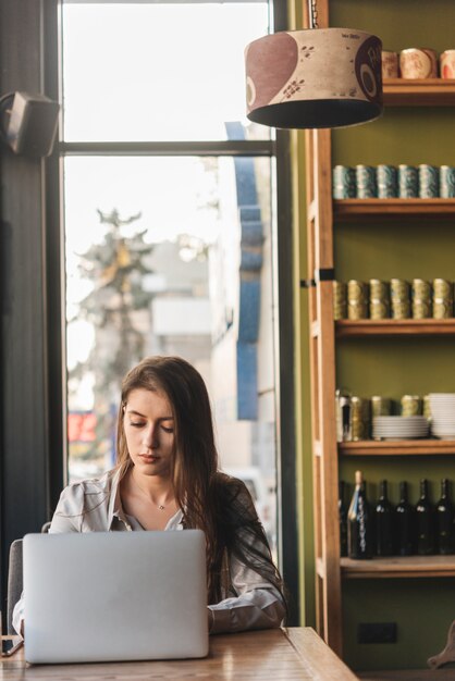 Freelance kobieta pracuje z laptopem w sklep z kawą