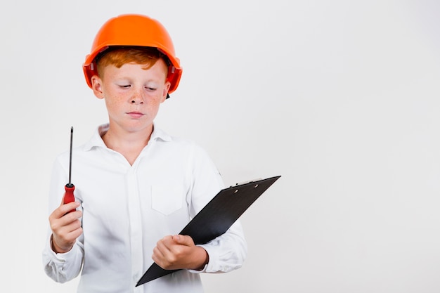 Frontowego widoku dziecko pozuje jako pracownik budowlany