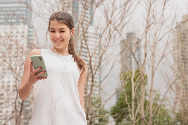 Frontowego widoku smiley kobieta trzyma jej telefon