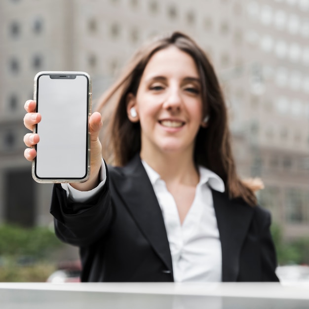 Frontowego widoku smiley kobieta trzyma up jej telefon