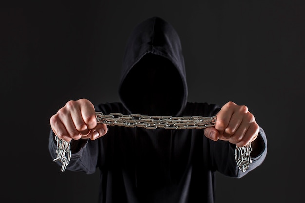 Frontowy widok męski hackera mienia metalu łańcuch w rękach