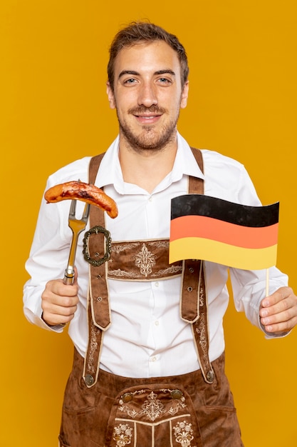 Bezpłatne zdjęcie frontowy widok mężczyzna mienia kiełbasa i flaga