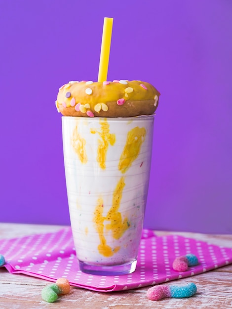 Bezpłatne zdjęcie frontowy widok milkshake szkło z purpurowym tłem