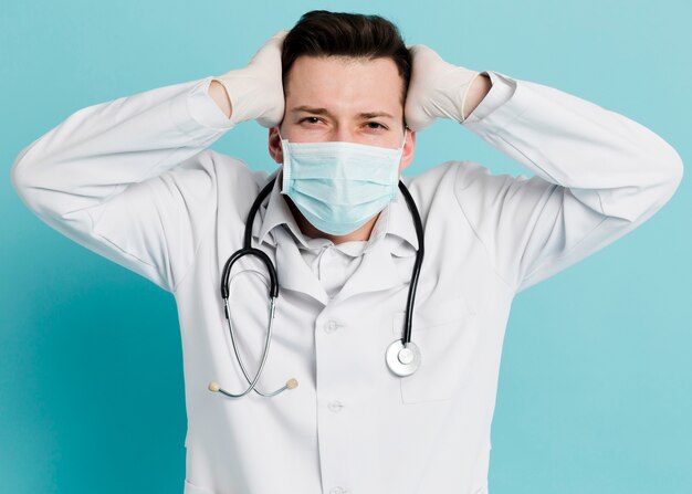 Frontowy widok pozuje doktorski podczas gdy będący ubranym medyczną maskę
