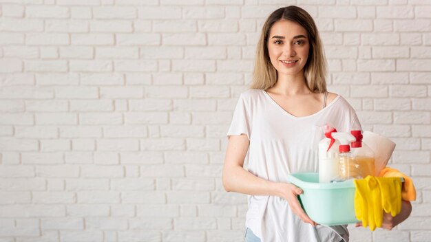 Frontowy widok smiley kobiety mienia wiadro z cleaning rozwiązaniami