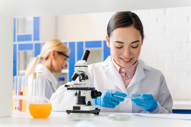 Bezpłatne zdjęcie frontowy widok smiley żeński naukowiec w lab