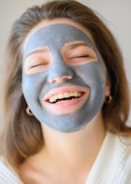 Frontowy widok szczęśliwa kobieta relaksuje w domu z twarzy maską