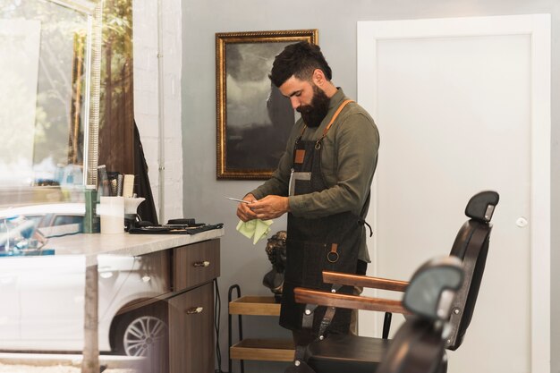Fryzjer przygotowuje sprzęt do pracy w sklepie fryzjerskim