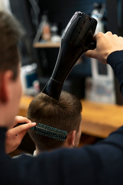 Bezpłatne zdjęcie fryzjer z bliska za pomocą suszarki do włosów