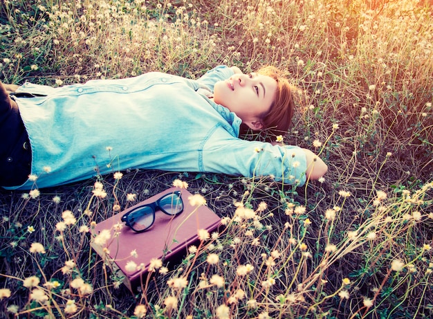 Bezpłatne zdjęcie girl odpoczynku leżącego wśród kwiatów