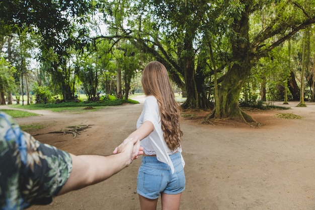 Girlfriend ciągnięcie chłopakiem w kierunku lasu