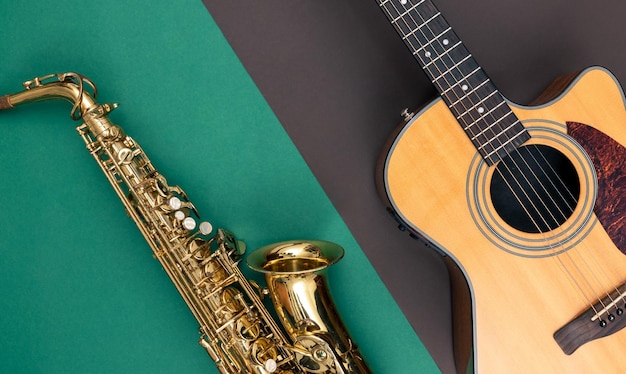 Bezpłatne zdjęcie gitara i saksofon na papierowym tle widok z góry