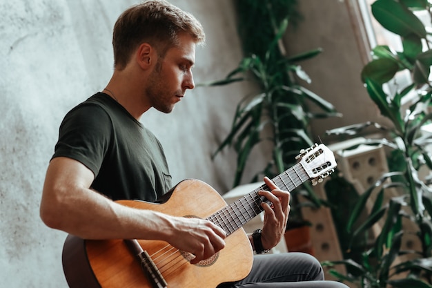 Bezpłatne zdjęcie gitarzysta mężczyzna gra na gitarze w domu