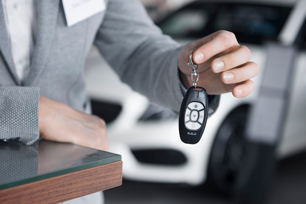 Bezpłatne zdjęcie główny widok sprzedawcy trzymającego kluczyki do samochodu
