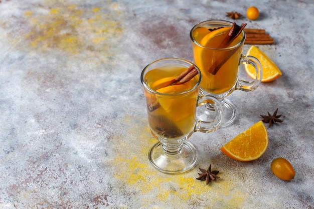 Gorąca zdrowa rozgrzewająca zimowa herbata z dodatkiem pomarańczy, miodu i cynamonu.