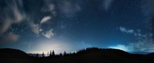 Górski las pod pięknym nocnym niebem z gwiazdami