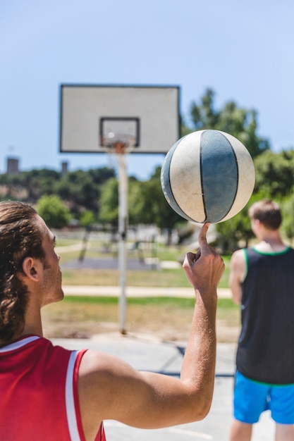 Bezpłatne zdjęcie gracz koszykówki przędzalniana piłka na jego palcu