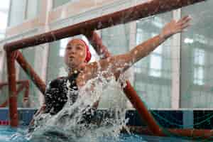 Bezpłatne zdjęcie gracz piłki wodnej na basenie ze sprzętem do pływania