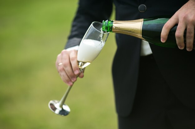 Groom nalewania szampana w flet