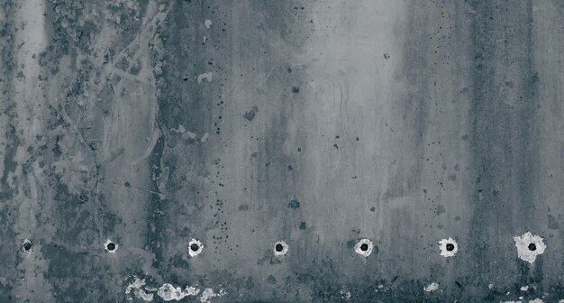 Grunge nierówny wyblakły beton tekstury powierzchni kamienia z ciemnymi plamami i wywierconymi otworami wierconymi lub dziurami po kulach