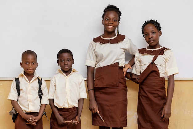 Grupa afrykańskich dzieci stojących obok siebie w klasie