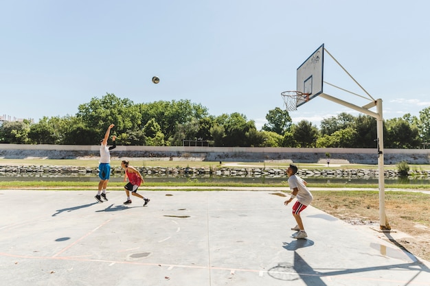 Grupa bawić się koszykówkę przy outdoors sądem gracz
