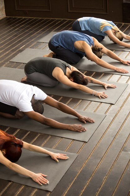 Grupa jogów ludzie w Balasana pozie