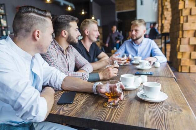 Grupa męscy przyjaciele cieszy się napoje w restauraci
