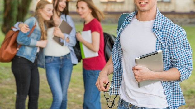 Grupa młodych studentów przed budynkiem szkoły