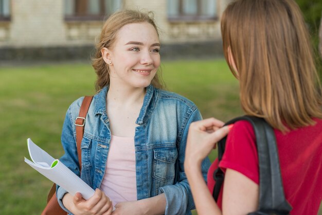 Grupa młodych studentów przed budynkiem szkoły