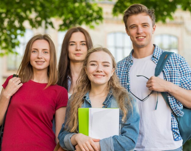 Grupa młodych studentów przed budynkiem szkoły