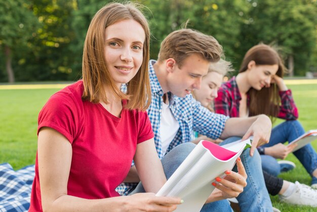 Grupa młodych studentów uczących się w parku