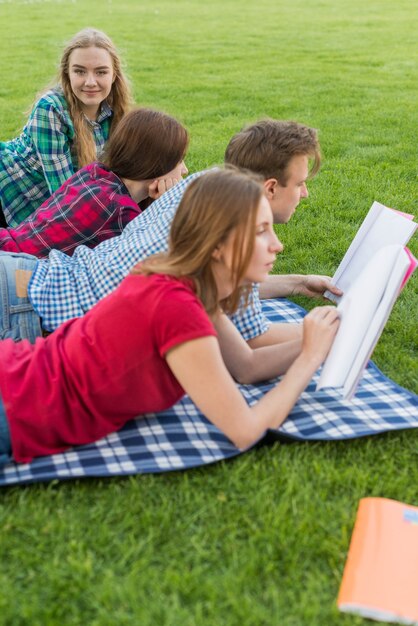 Grupa młodych studentów uczących się w parku