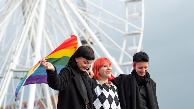 Bezpłatne zdjęcie grupa osób niebinarnych z flagą lgbt