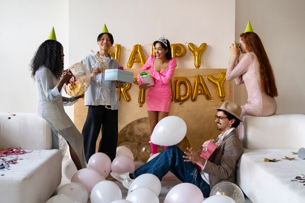 Grupa przyjaciół bawiąca się razem na przyjęciu urodzinowym-niespodziance