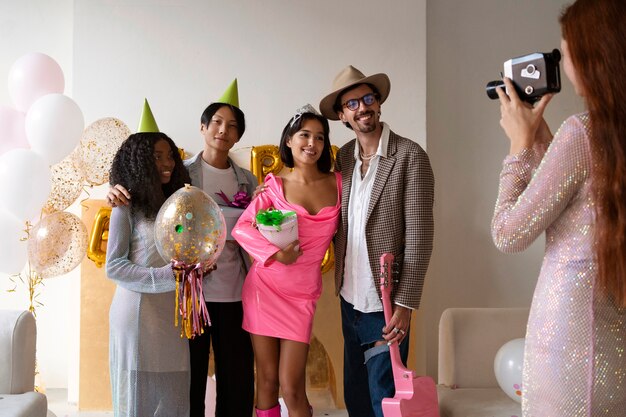 Grupa przyjaciół bawiąca się razem na przyjęciu urodzinowym-niespodziance