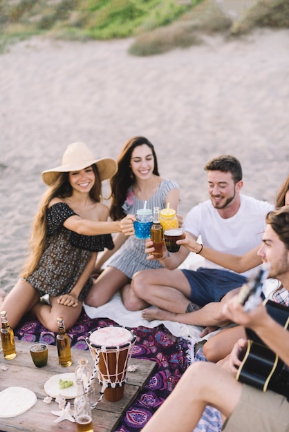 Bezpłatne zdjęcie grupa przyjaciół siedzi na plaży