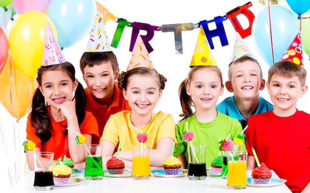 Grupa szczęśliwych dzieci w kolorowe koszule, zabawy na przyjęciu urodzinowym - na białym tle.