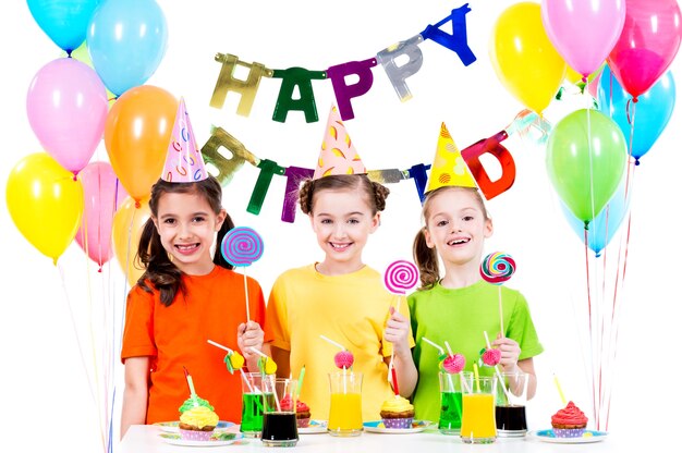 Grupa szczęśliwych dziewcząt z kolorowych cukierków, zabawy na przyjęciu urodzinowym - na białym tle
